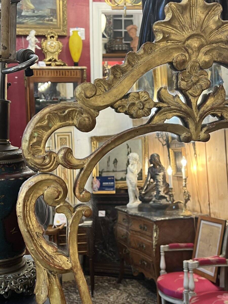 Mirror with carved and gilded wooden frame, 18th century, with scrollwork decoration.