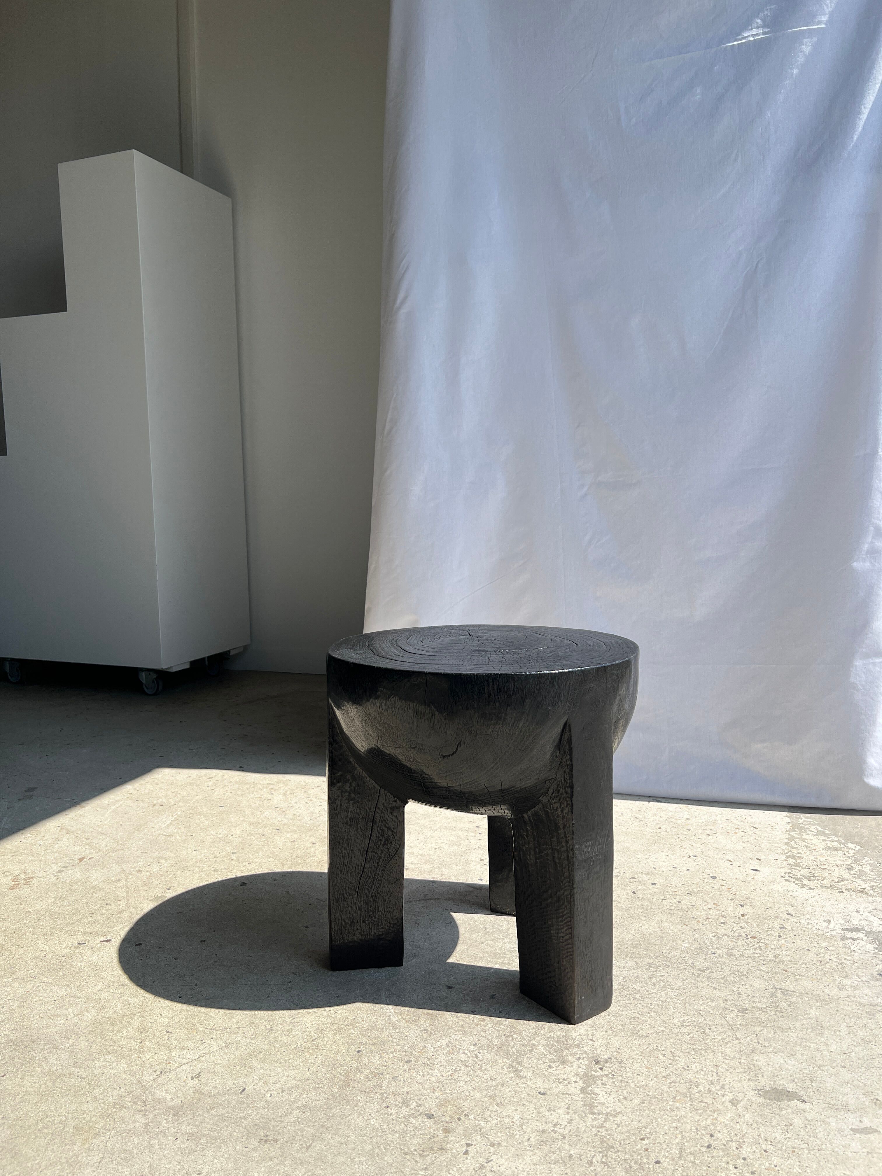 Black mango wood tripod side table with a semi-spherical top, height: 45 cm, diameter: 44 cm.