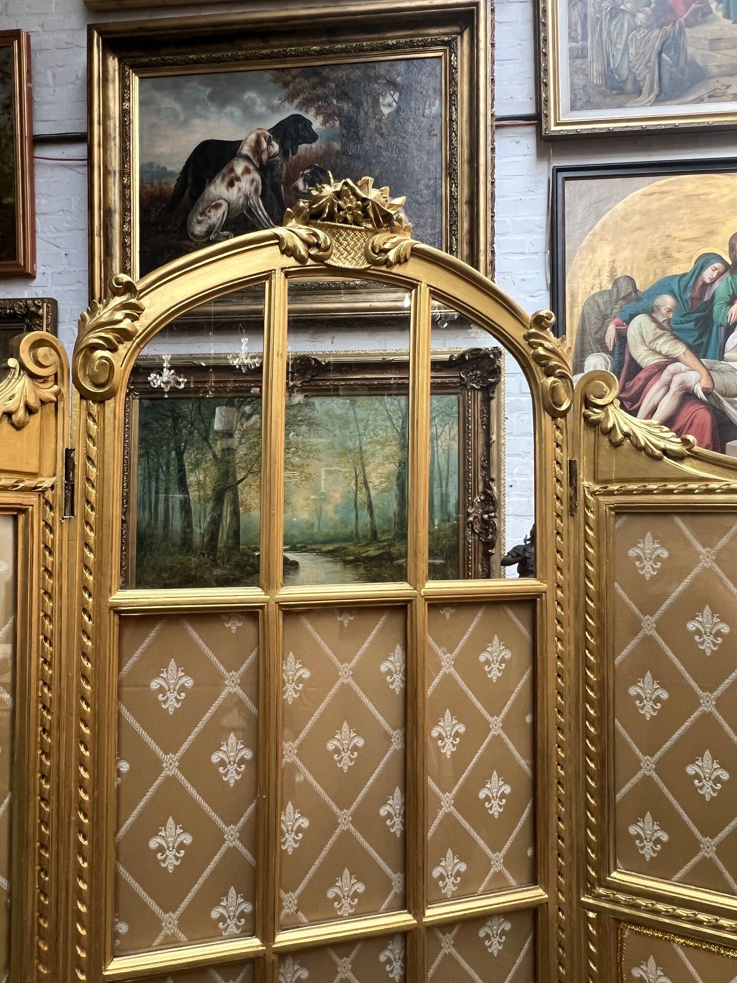 Paravent en bois doré décoré dans le style Louis XVI, orné de têtes de bélier.