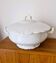 White porcelain soup tureen from Limoges with a vegetal scroll design.