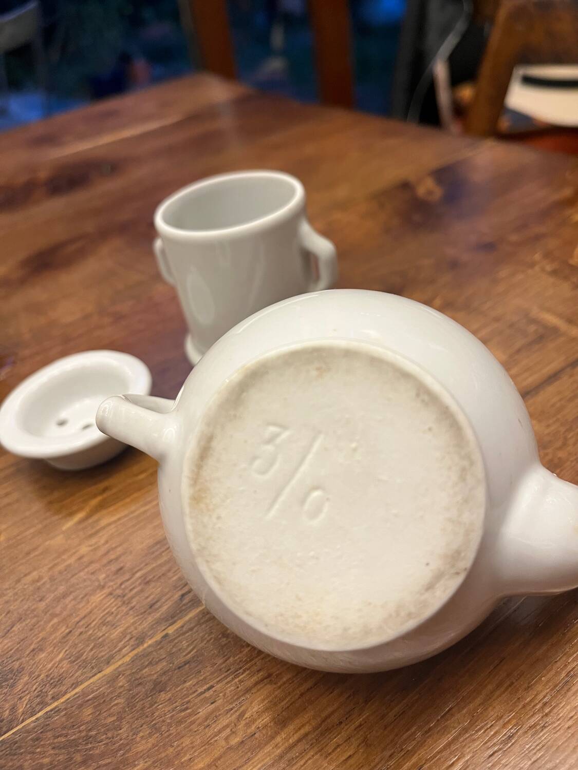 Antique white earthenware teapot, individual service with filter.