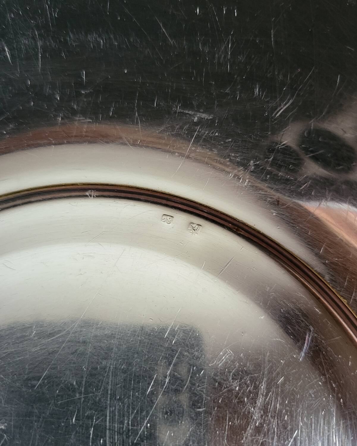 Shallow round metal plate with pearl bead decoration.