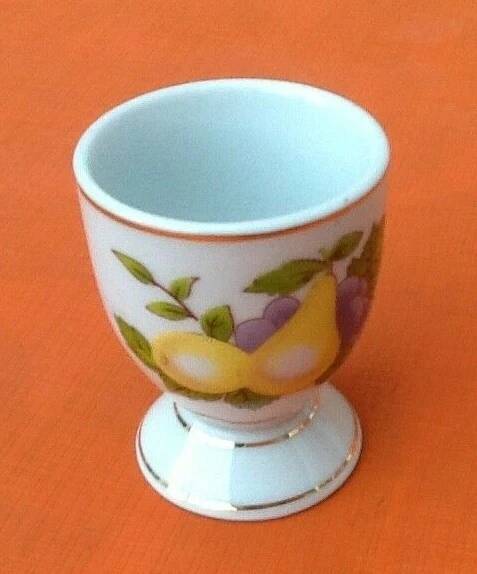 White porcelain egg cup decorated with pears / grapes.