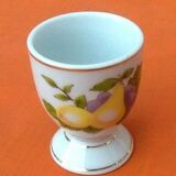 White porcelain egg cup decorated with pears / grapes.