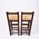 Set of 2 vintage wooden bar stools with woven straw seats.