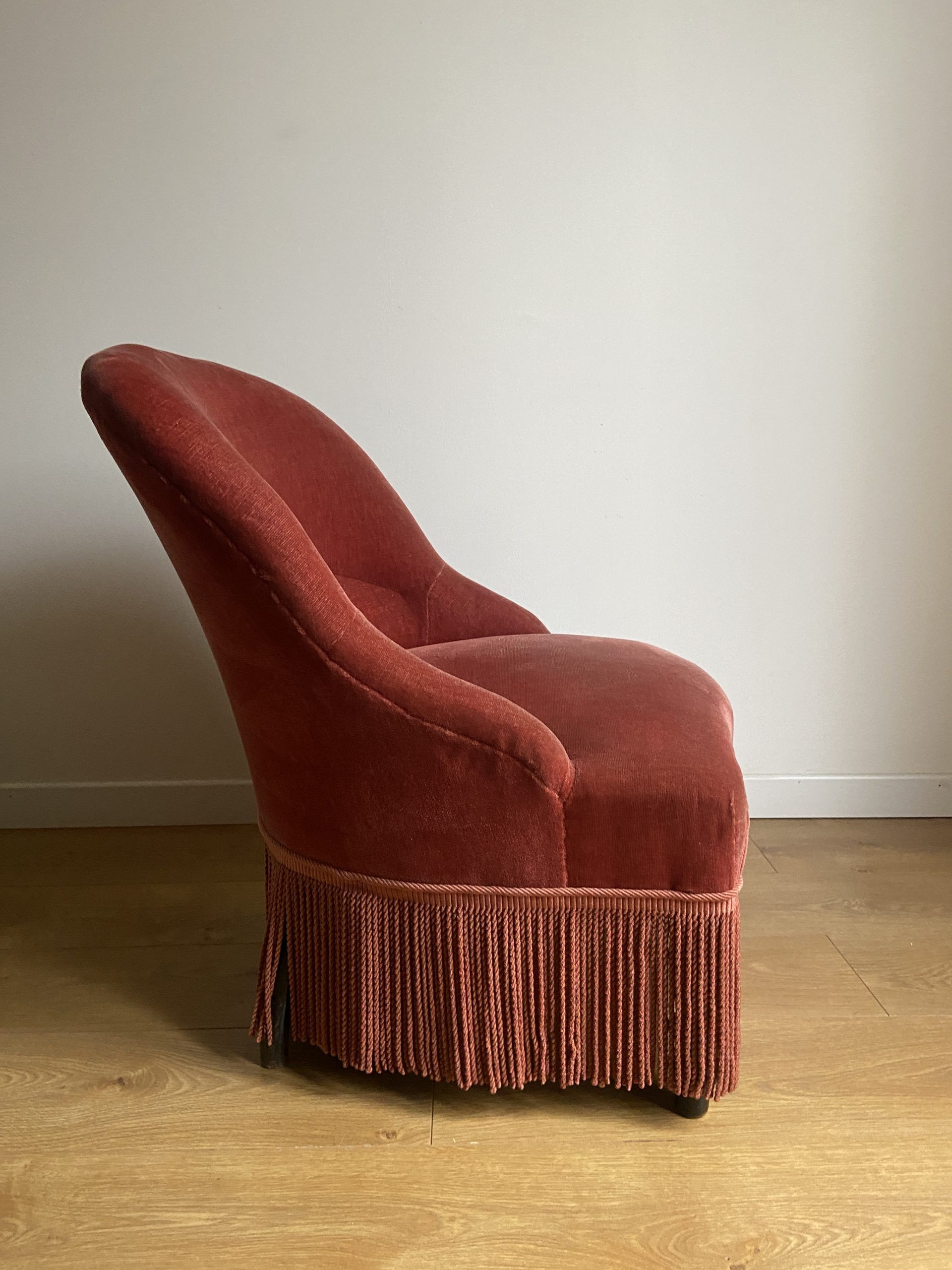 Fauteuil crapaud vintage rose framboise en velours à franges