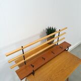 Vintage wall coat rack with black hooks and light wood