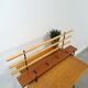 Vintage wall coat rack with black hooks and light wood