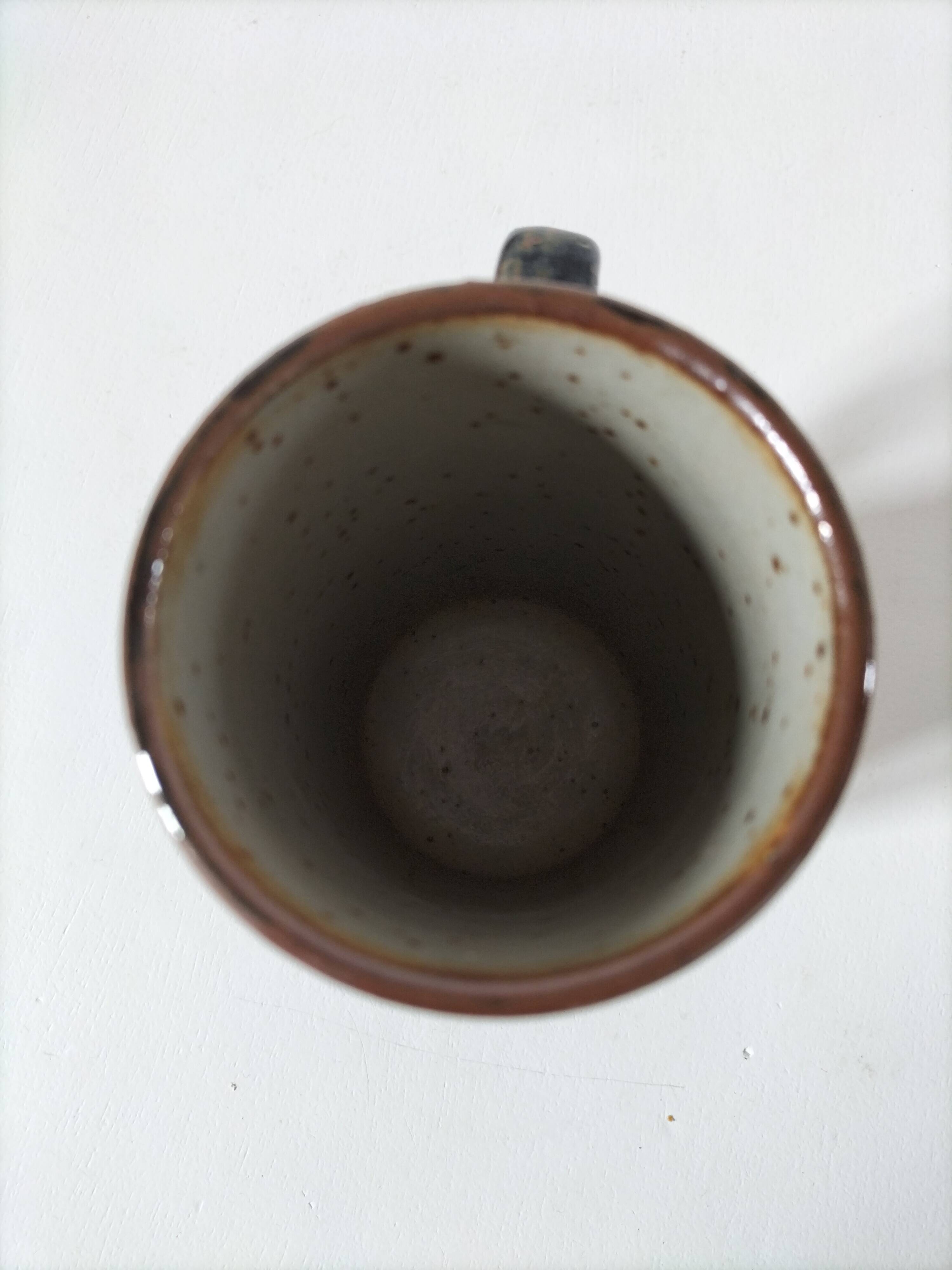 Glazed stoneware mug with free decoration, vintage pottery work.