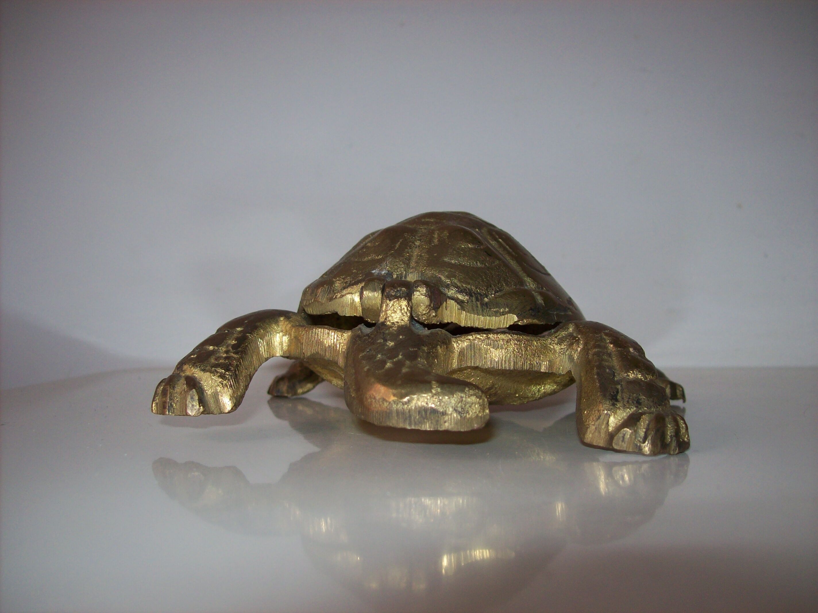 Golden brass ashtray has a turtle-shaped