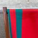 Vintage folding wooden deck chair with red and green striped canvas from the 1970s.