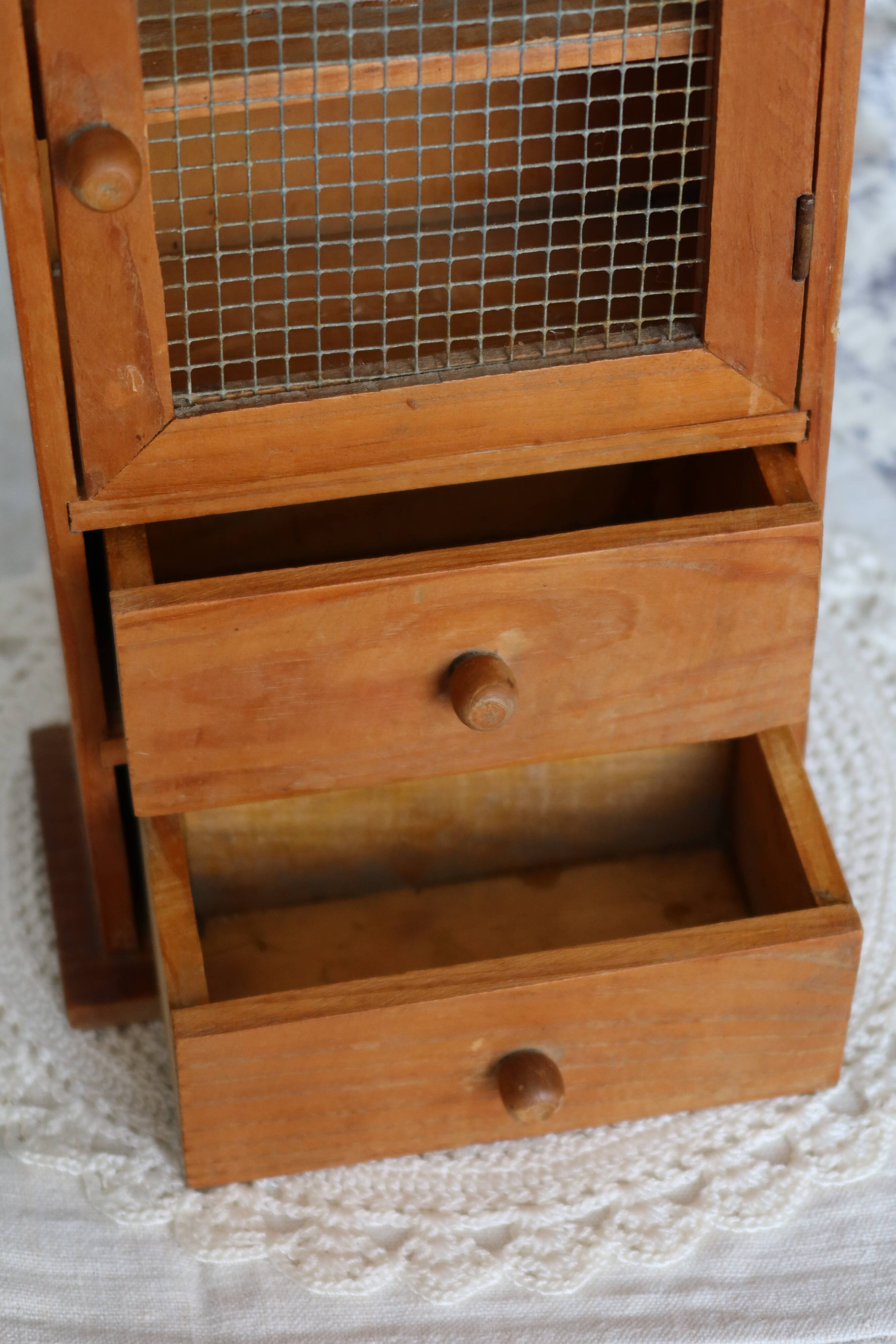 Vintage wooden shelf with drawers and mesh door.