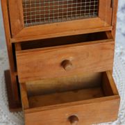 Vintage wooden shelf with drawers and mesh door.