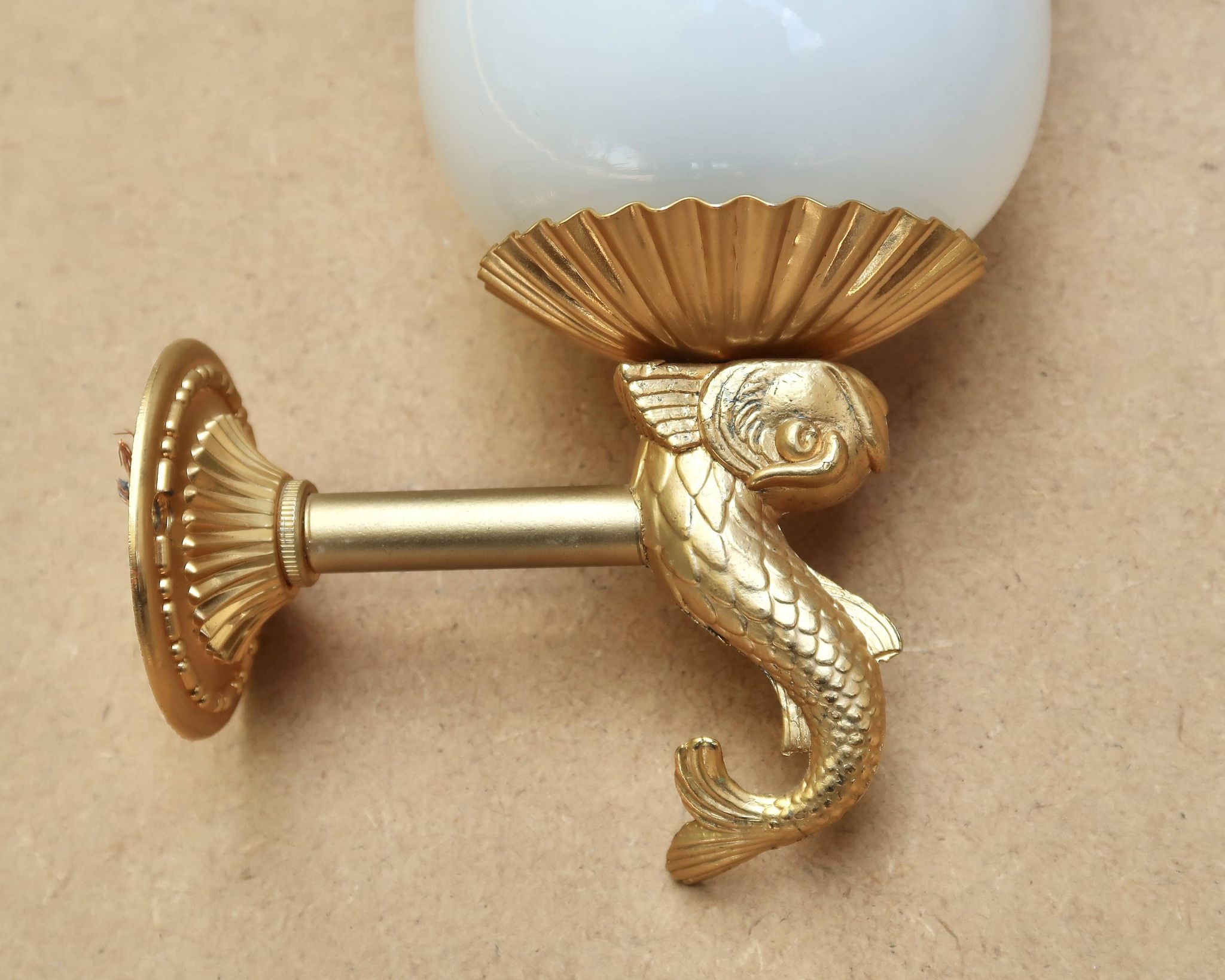 Pair of gold metal and opaque glass wall lights adorned with fish from the 1950s.