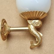 Pair of gold metal and opaque glass wall lights adorned with fish from the 1950s.