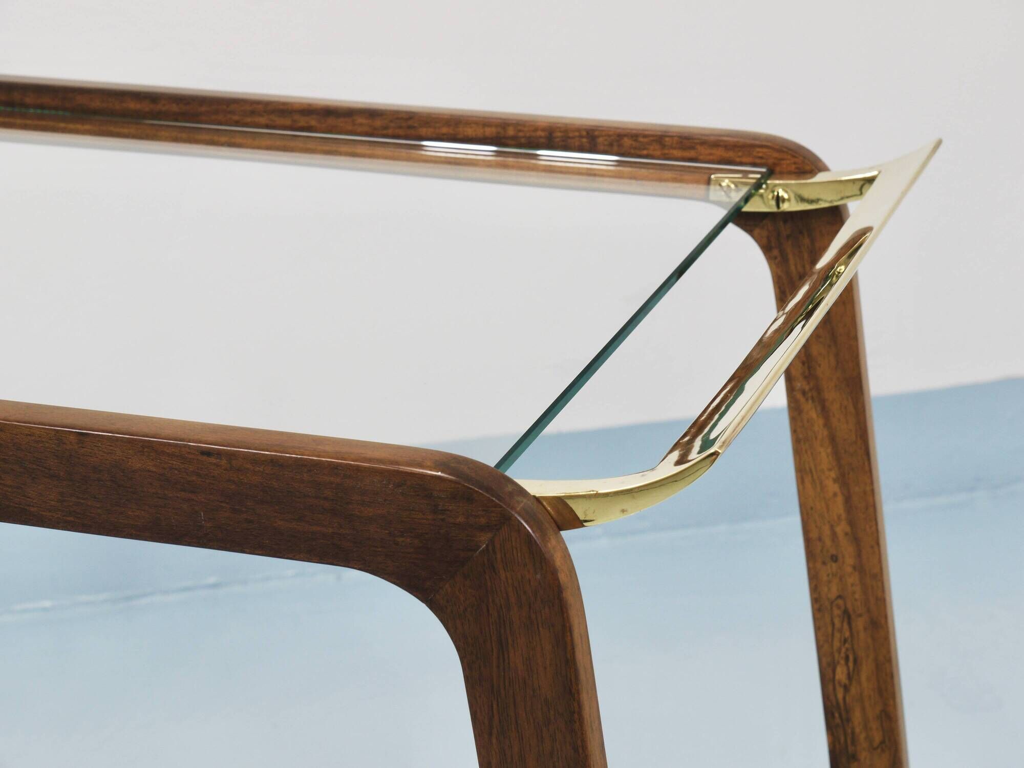 May include: A mid-century modern bar cart with a dark wood frame and two c