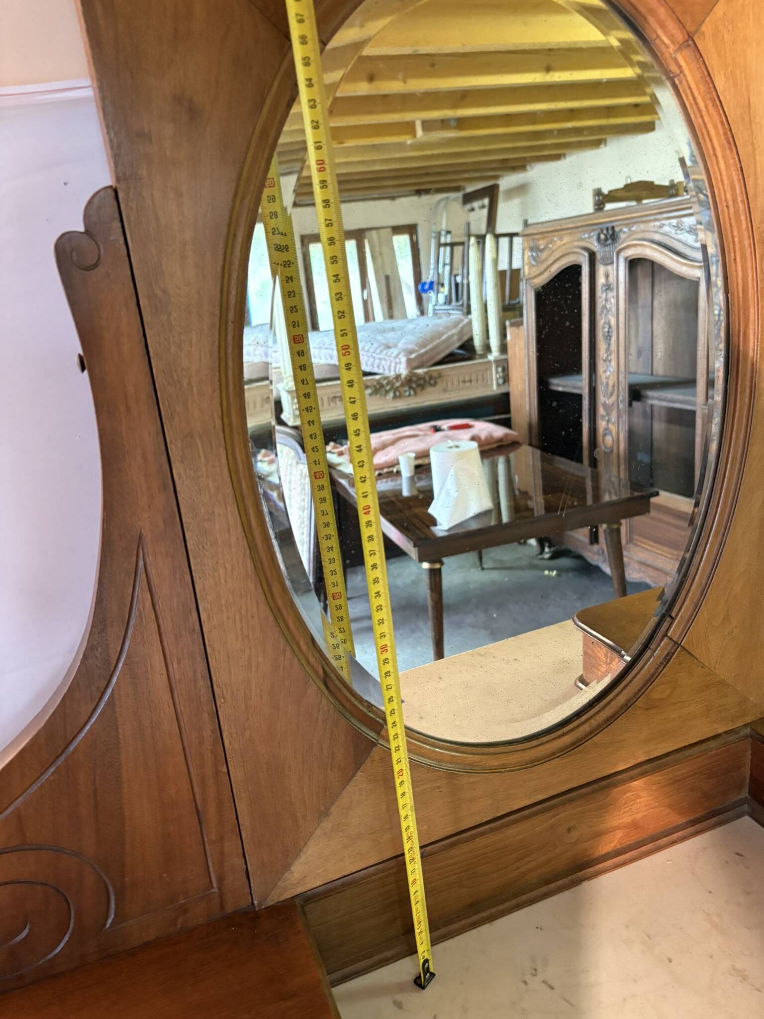Antique carved wooden dressing table with marble and tilting oval mirror.