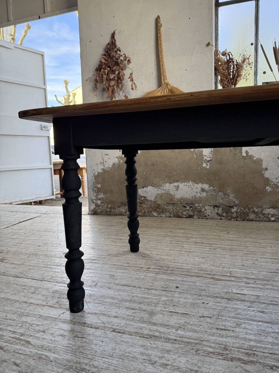 Oak farmhouse table with turned black legs.