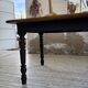 Oak farmhouse table with turned black legs.