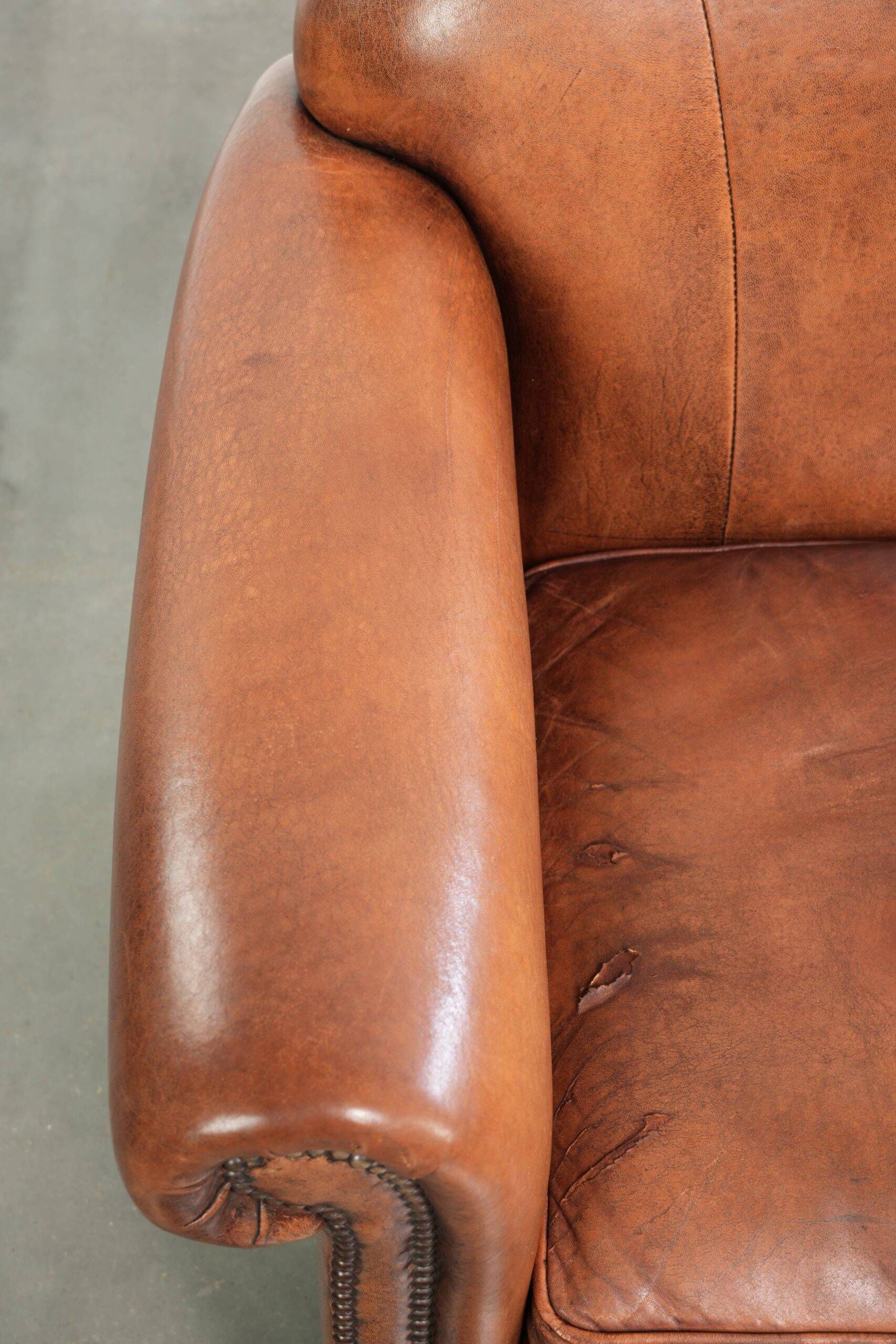 Comfortable vintage sheepskin armchair finished with decorative nails
