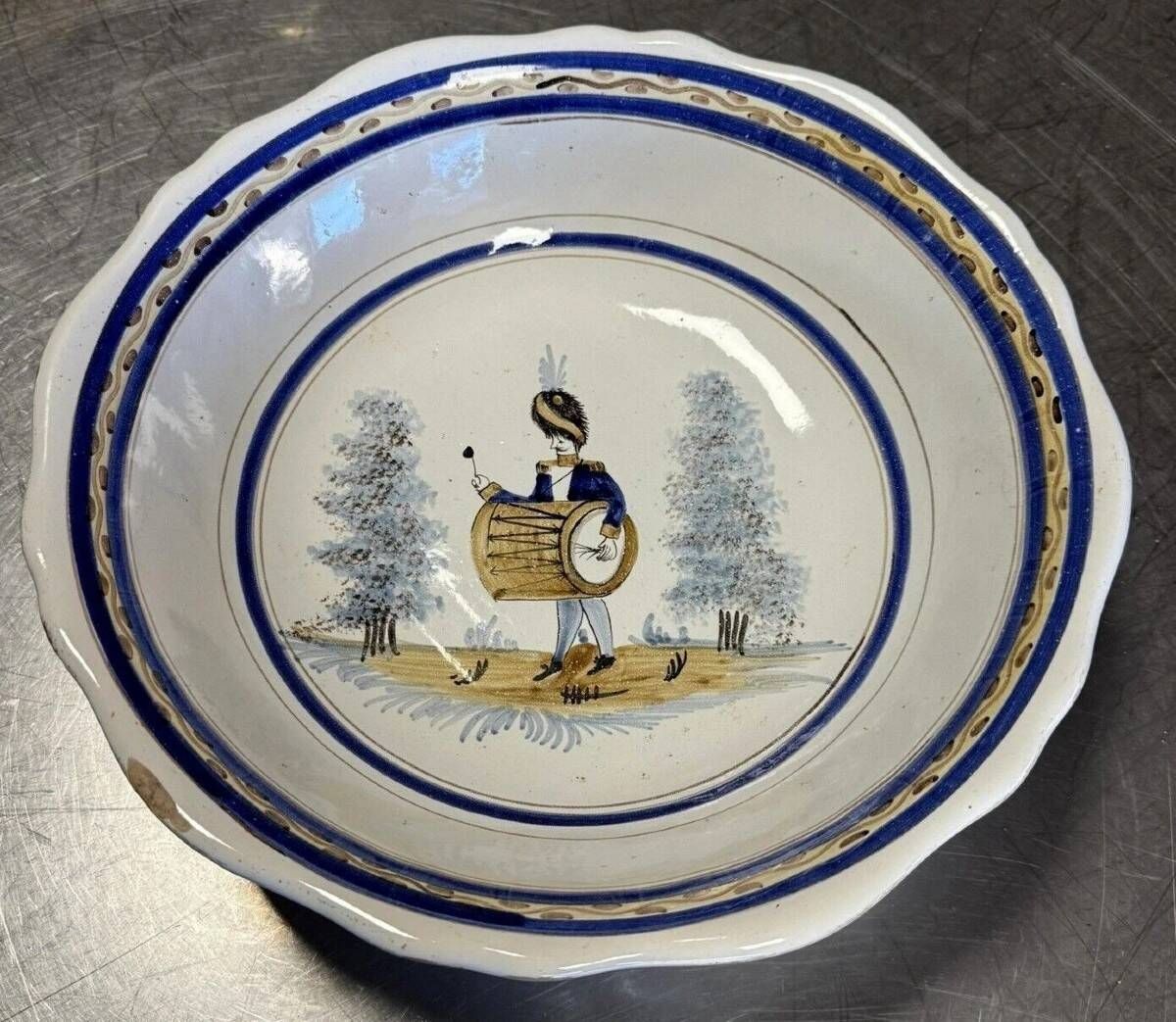 Large centrepiece table dish in earthenware with a painted decoration of a drummer.