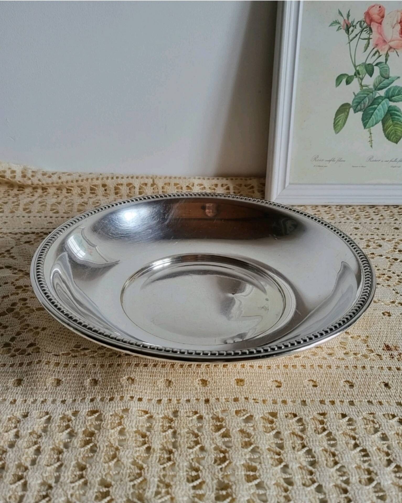 Shallow round metal plate with pearl row decoration.