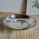 Shallow round metal plate with pearl row decoration.