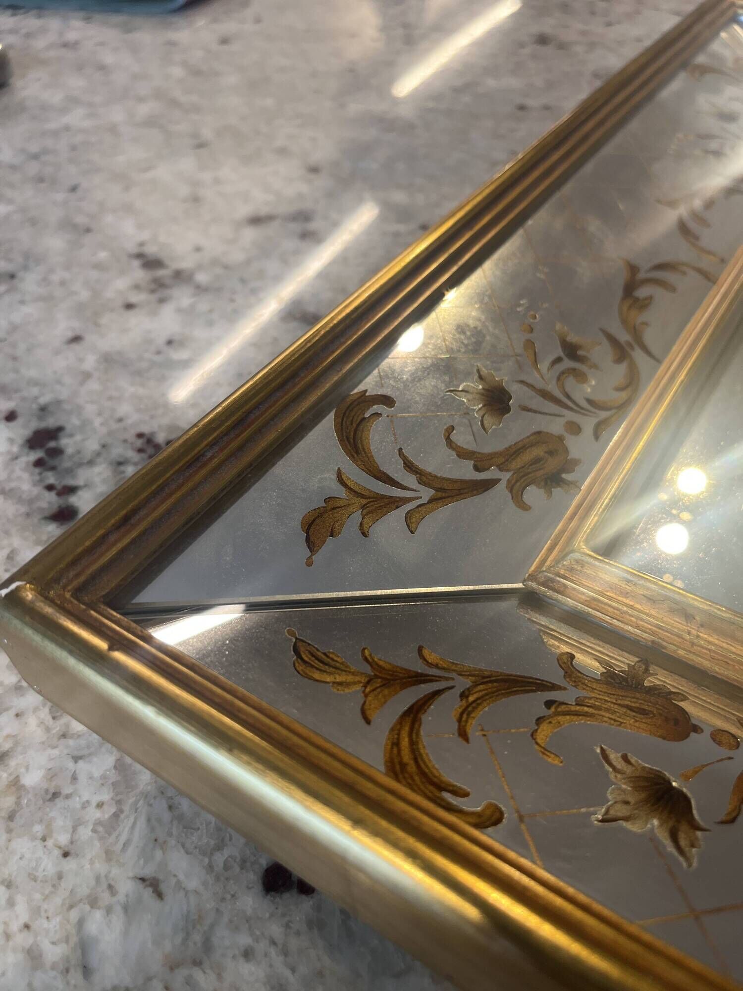 Large Venetian-style mirror with golden floral decoration.
