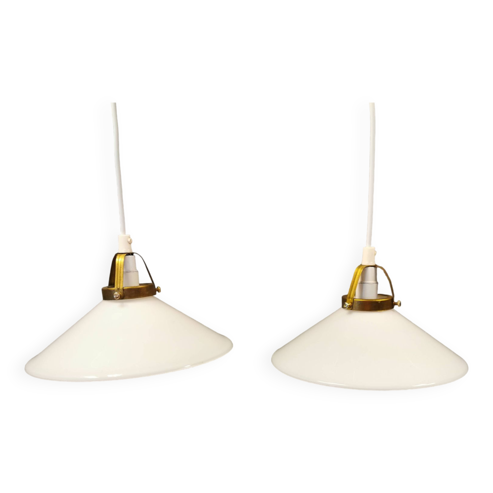 A set of hanging lamps in milky white opal glass with brass top.