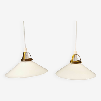 A set of hanging lamps in milky white opal glass with brass top.