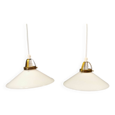 Un ensemble de lampes suspendues en verre opale blanc laiteux avec dessus en laiton.