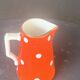 Milk jug, pitcher with white polka dots on orange earthenware, Sarreguemines and Digoin