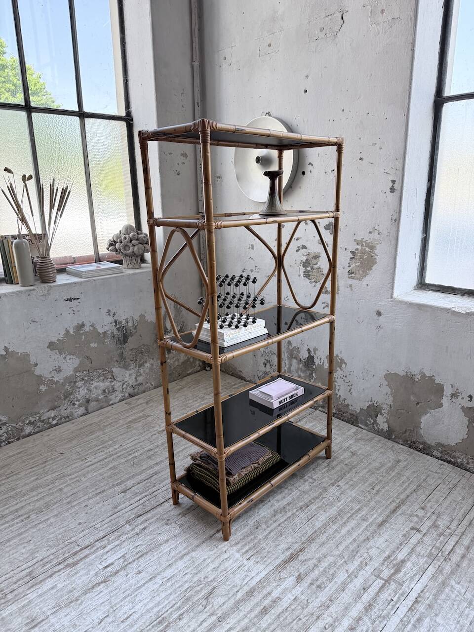 Rattan bookshelf and black glasses