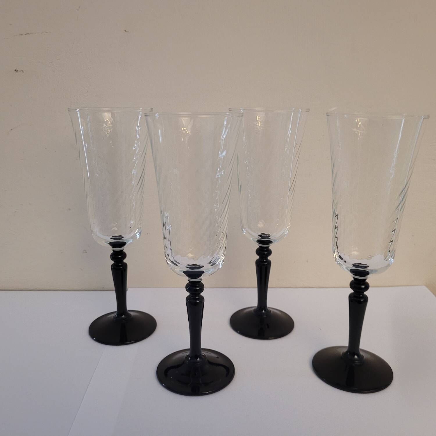 4 clear glass flutes with black stems. 1960–1970. 4 clear glass flutes with black stems.