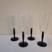 4 clear glass flutes with black stems. 1960–1970. 4 clear glass flutes with black stems.