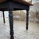 Oak farmhouse table with turned black legs.