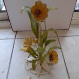 White wrought iron lamp with pink and yellow flowers and green leaves.