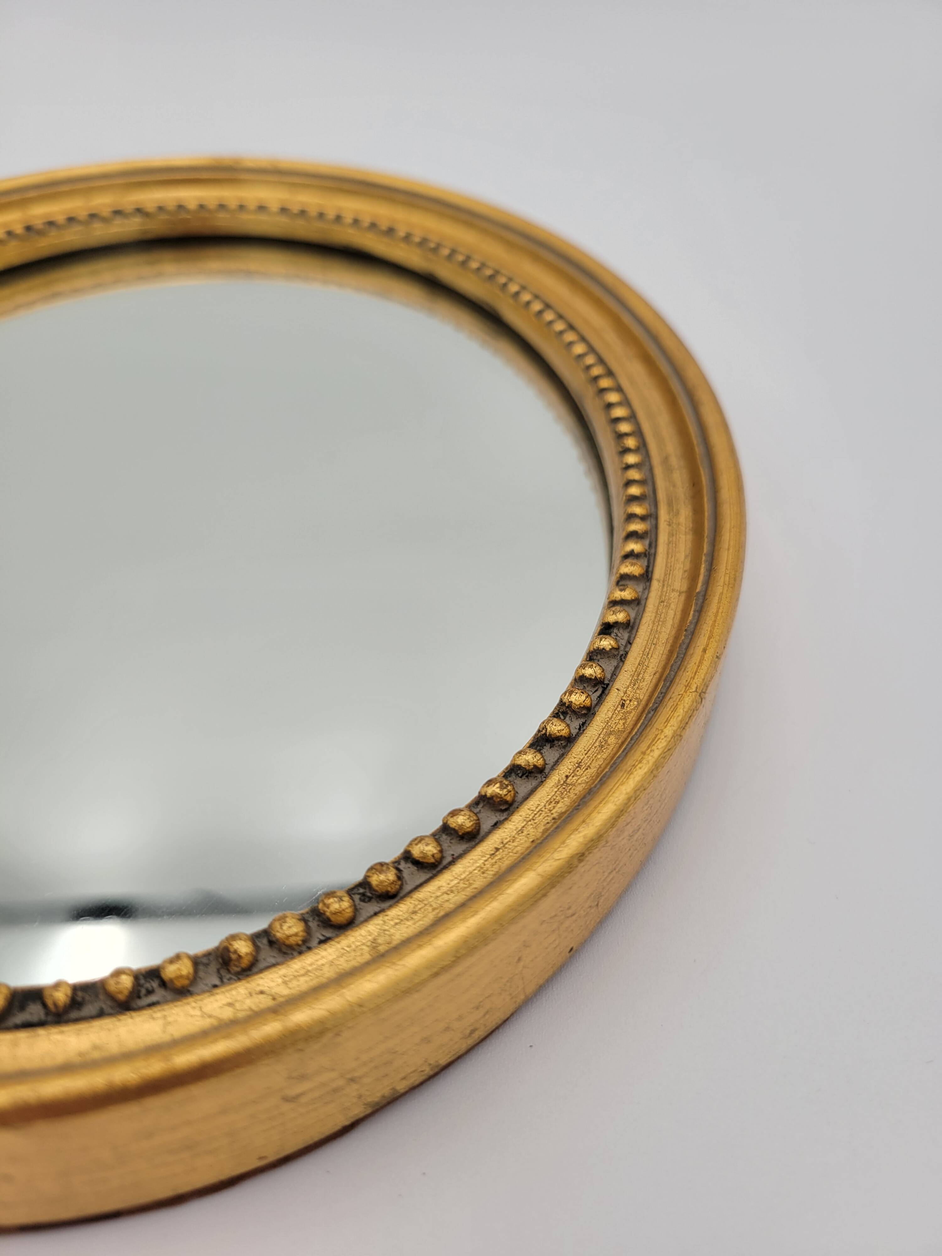 Small old oval mirror in gilded wood