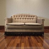 Vintage beige two-seater canapé with fringes.