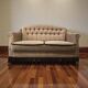 Vintage beige two-seater canapé with fringes.