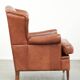 Fauteuil anglais à oreilles de couleur cognac clair en cuir de vache.