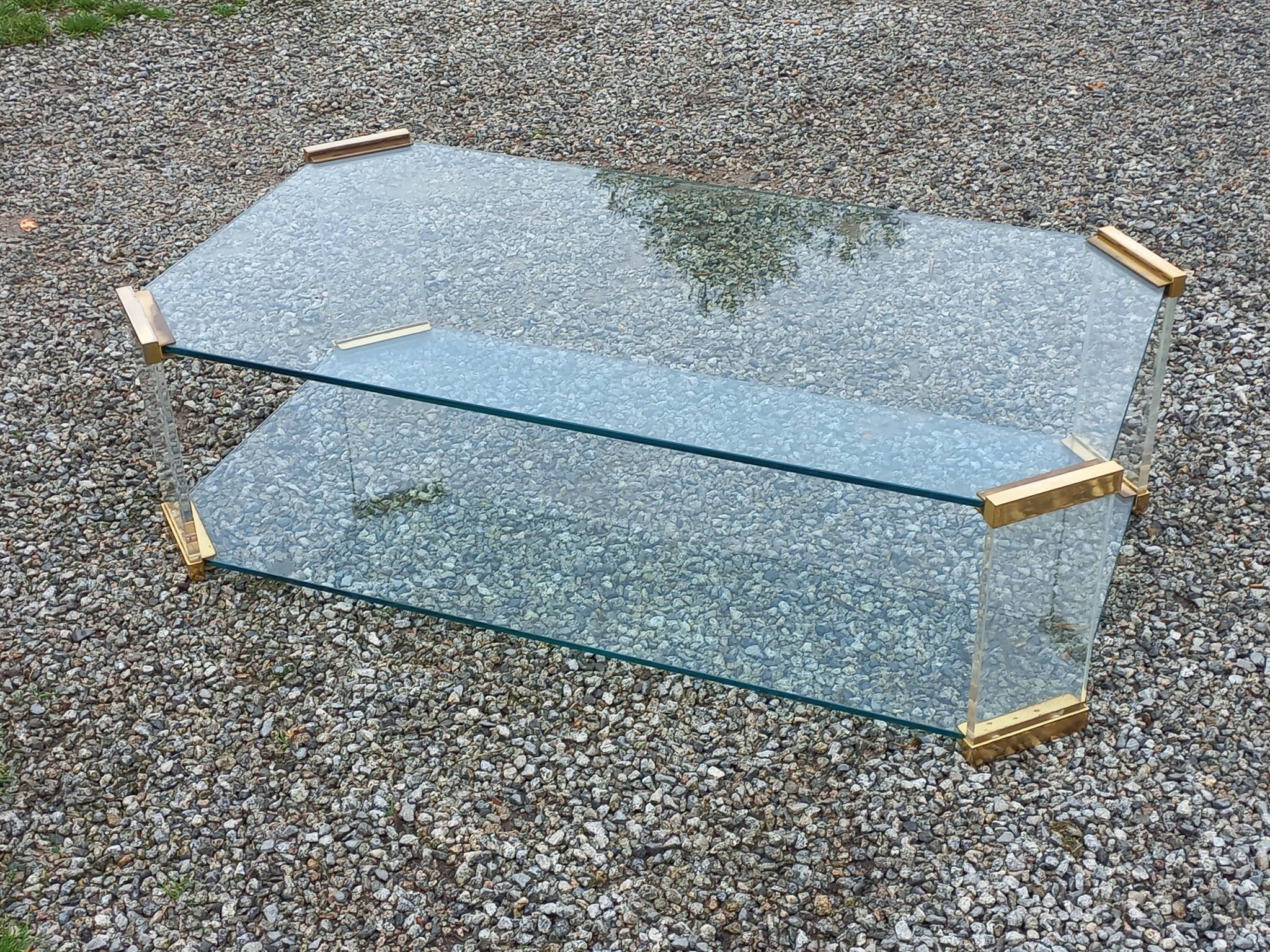 1970s designer coffee table in glass, plexiglass, and gold metal.