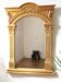 Golden wooden mirror with an ornate pediment.