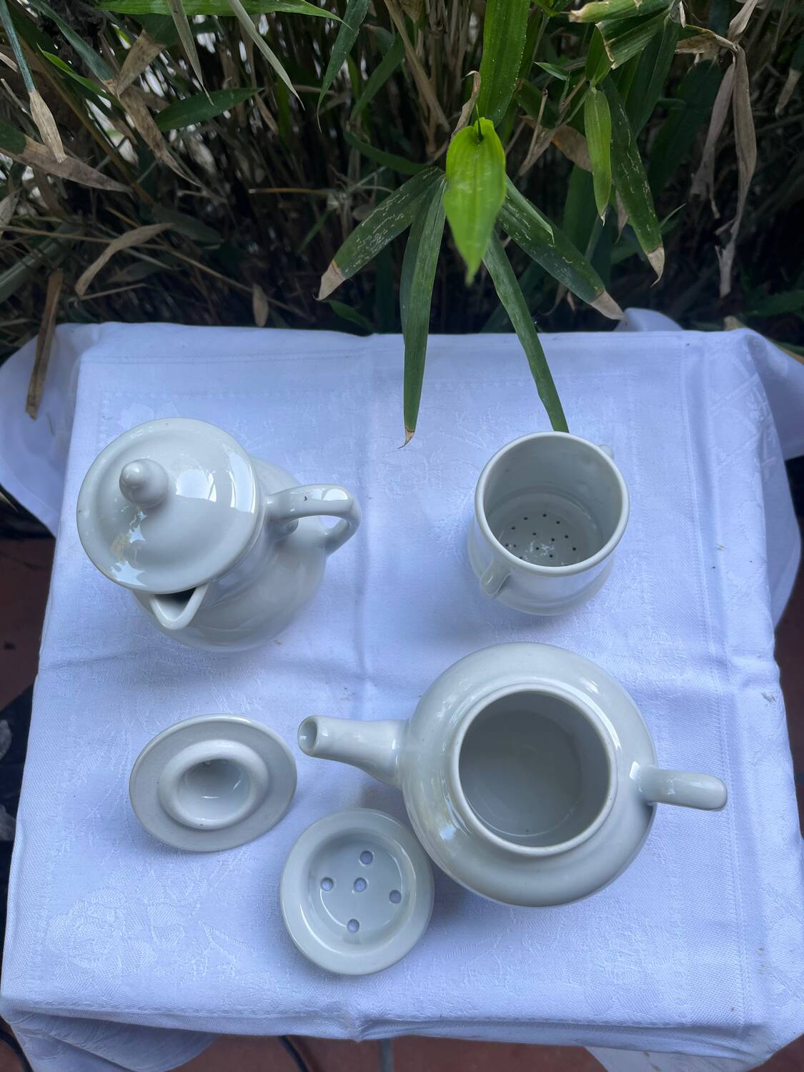 Antique white earthenware teapot, individual service with filter.