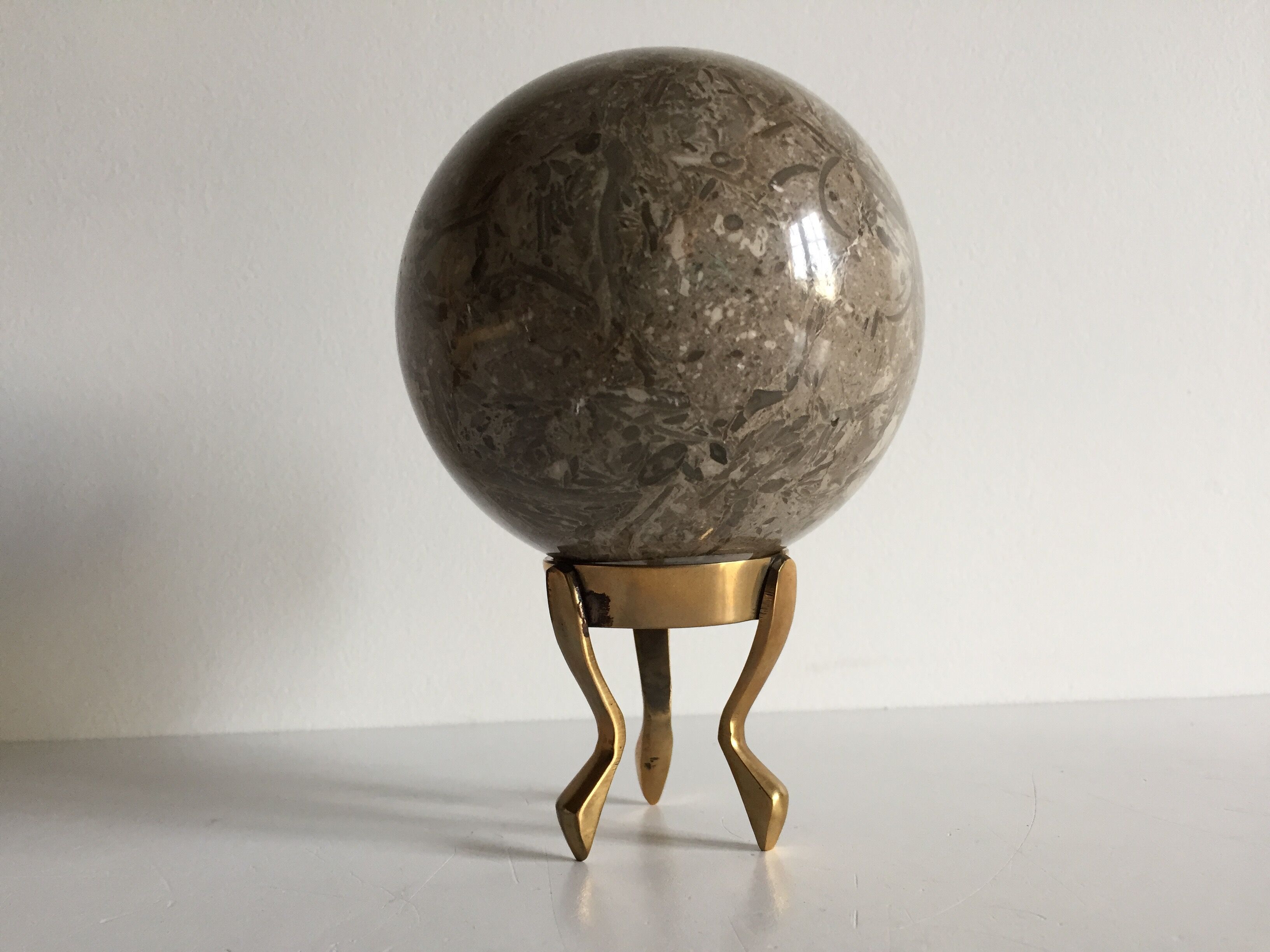 Marble ball paperweight on vintage brass