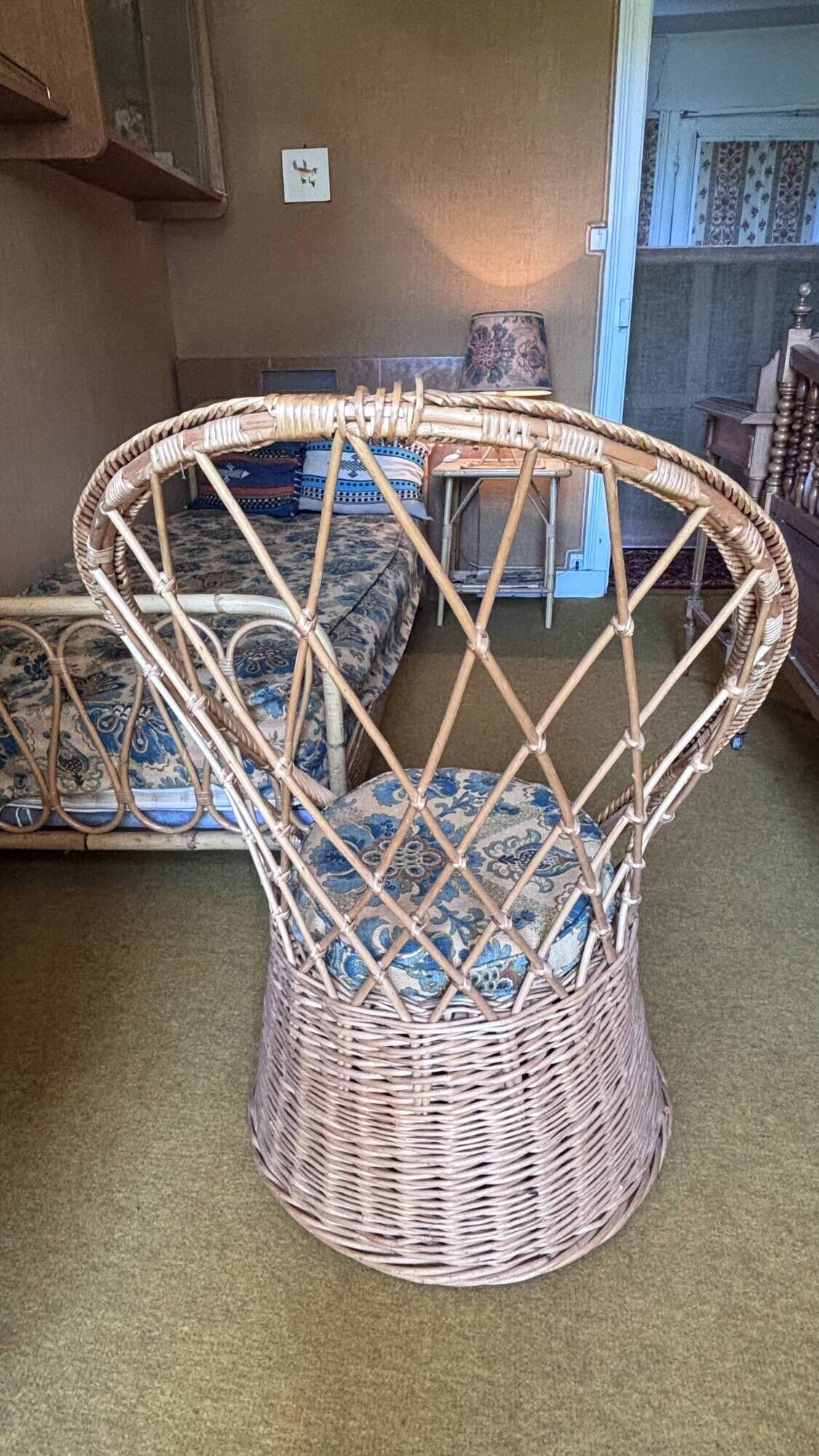Vintage shell chair in woven rattan with original cushion.