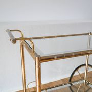 Desserte en métal doré et verre à grandes roues 1950