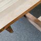 Round extendable dining table stripped in solid raw walnut with a central leg.