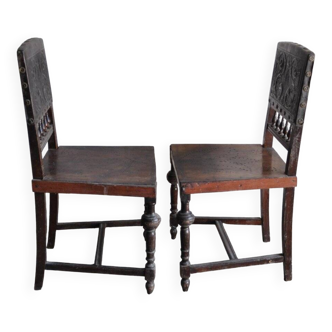 Pair of antique wooden and brown leather dining chairs, brass studs.