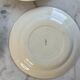 Set of 4 small flat plates with floral designs.
